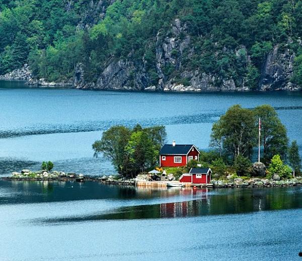 Ein rotes Haus am Tyrrheinischen Meer gelegen mit Blick auf eine Felschlandschaft. 